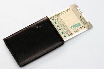 New Indian currency of 500 rupee notes into the money purse.