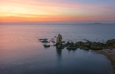 Fototapeta na wymiar a pillar stay lonely in the sea shore of east part of Thailand in Sunset Scenery