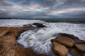 Cloudy dramatic sky, big waves, cloudscape just before the storm near the shore