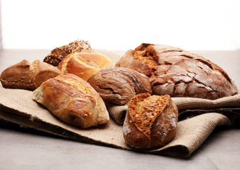 Different kinds of bread rolls on black board from above. Kitchen or bakery poster design.