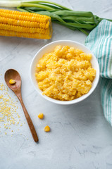 Corn porridge on a concrete background. Vertical photo.