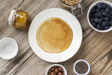 Healthy breakfast trend. Fine grain oat pancakes with chocolate cream and assorted fruits  berries strawberries, blueberries, chia seeds, granola, nuts  honey. The concept of organic 