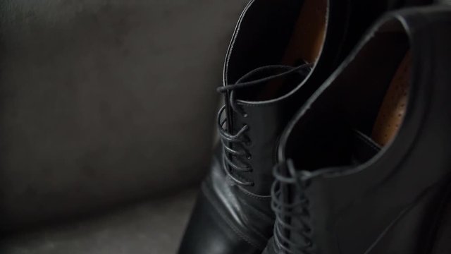 Wedding rings lie on napkin before leather shoes