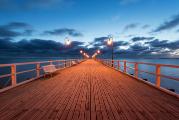 Wooden pier in Gdynia Orlowo in the night with blue sky. Poland. Europe.