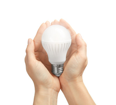 Woman holding light bulb on white background