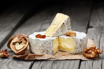 Creamy Camembert with nuts,raisins and on rustic wooden background.selective focus