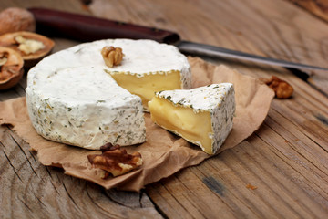 Creamy Camembert with nuts,raisins and on rustic wooden background.selective focus