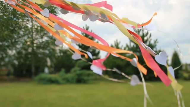 Wind blows colorful ribbons and paper hearts