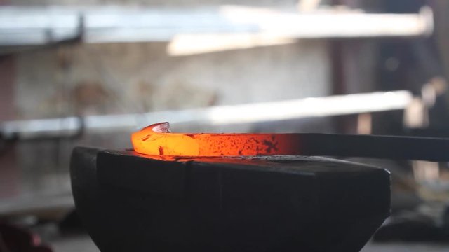 Forging hot metal in smith with hand hummer