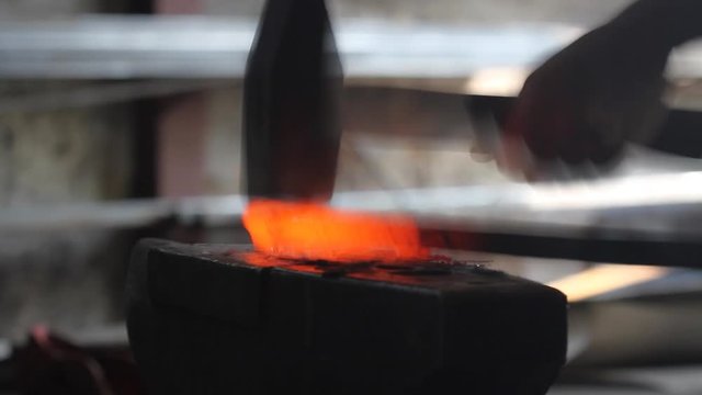 Forging hot metal in smith with hand hummer
