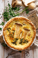 Mushroom quiche on a wooden table, top view