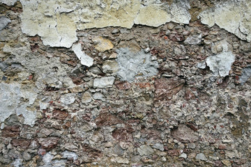 Close up view of crumbling plaster brick wall