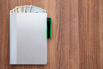 The daily log with denomination dollars on a wooden table.