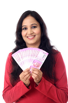 Young woman holding Indian 2000 rupee notes against white background