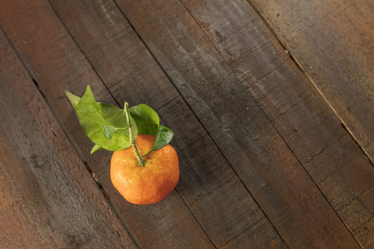 Tangerine on rustic wooden texture with copyspace