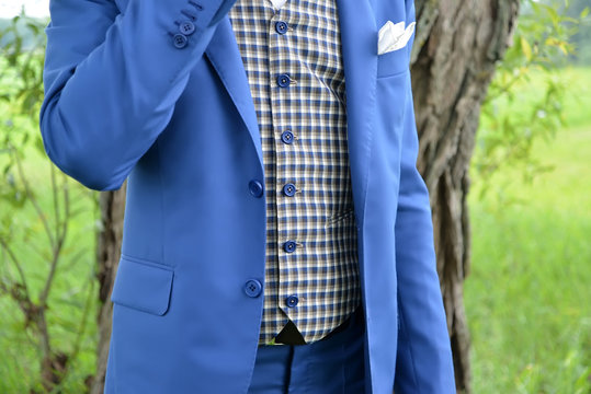 Torso of the young man in a blue jacket and a checkered vest