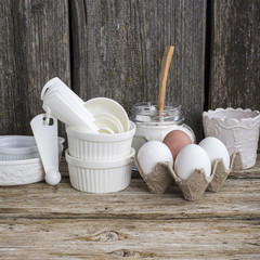 Kitchen cooking utensils in ceramic storage pot on a shelf   rustic wooden wall