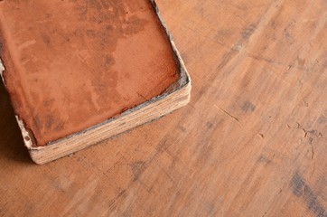 Tan vintage leather bound book laying on old rustic wood