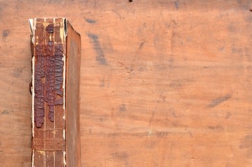 Crumbling Spine of a vintage leather bound book on old rustic wood