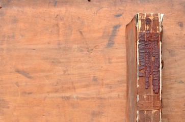 Crumbling Spine of a vintage leather bound book on old rustic wood