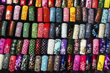 Nail samples, big collection of fingernails painted in various color with different pattern, selective focus