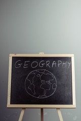 Geography lesson on blackboard or chalkboard. written in white chalk
