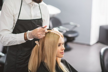 Naklejka premium Young woman is sitting at hairdressers
