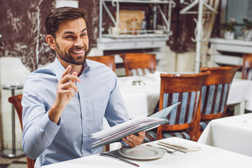 Smiling visitor waiting for waiter