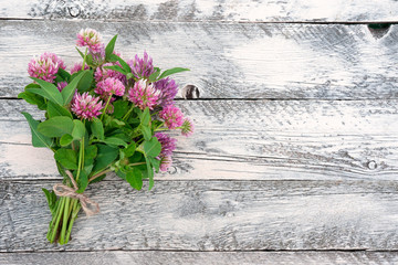 Clover bouquet on a wooden table. Romantic image by St. Valentine's Day. Top view. Copy space