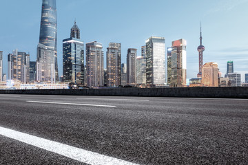 Obraz premium Asphalt road and modern cityscape at dusk in Shanghai