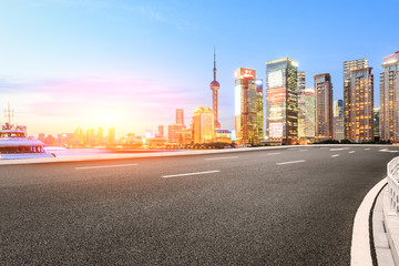 Asphalt road and modern cityscape at sunset in Shanghai
