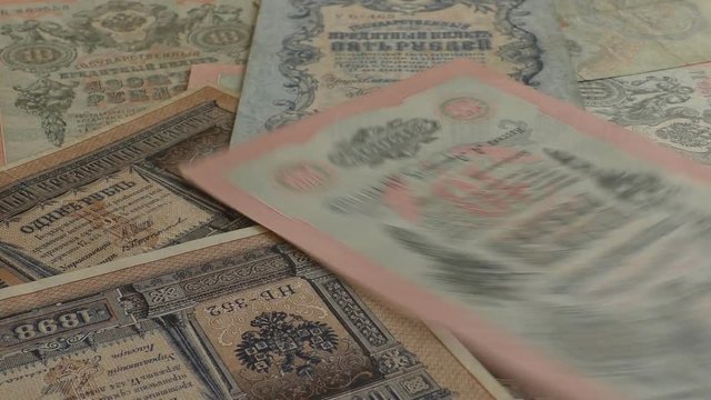 Old Russian imperial bank notes being counted and falling onto the pile