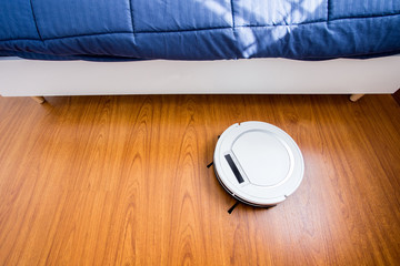 Robotic vacuum cleaner in bedroom.
