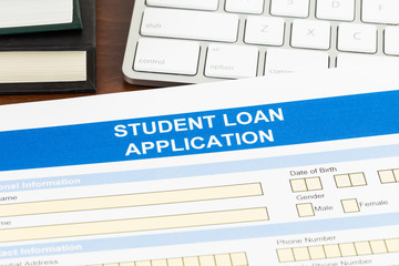 Student loan application form with keyboard, and text book