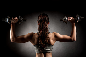 Atractive fit woman works out with dumbbells as a fitness concep