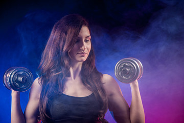 Atractive fit woman works out with dumbbells as a fitness concep