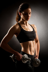 Atractive fit woman works out with dumbbells as a fitness concep