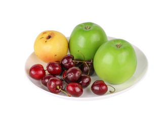 Apple, cherry and pear fruits in a plate isolated on the white background