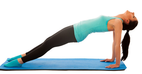 Woman doing stretching exercises on blue mat isolated over white