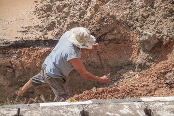 worker male dig a hole to fix  water leak at  large  on the road