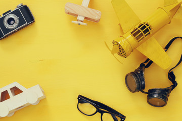 Top view of vintage yellow toy plane, old photo camera