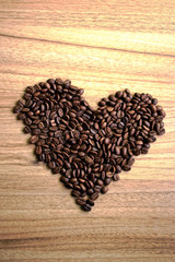 Coffee beans in a heart shape on a wooden table