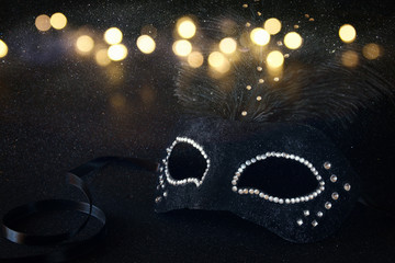 Image of black elegant venetian mask on glitter background. Shiny overlay