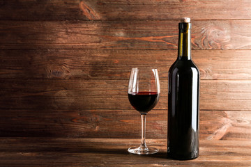 Wine bottle and glass on wooden background
