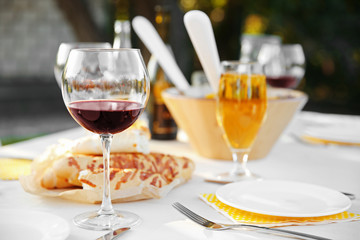 Plate, fork and glass of red wine on table, close up view