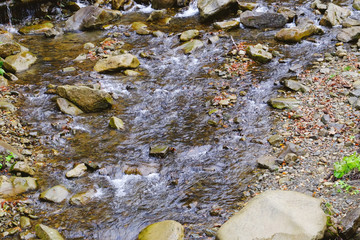 Stream flowing through rocky path in mountains
