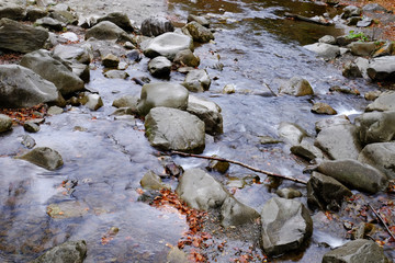 Stream flowing through rocky path in mountains