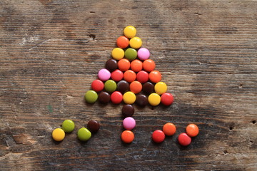 Christmas tree made with colorful candies on wooden table