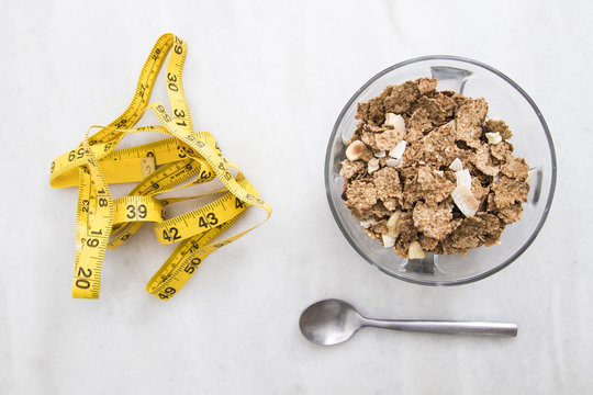bowl of cereal with measuring tape, concept of slimming and healthy diet