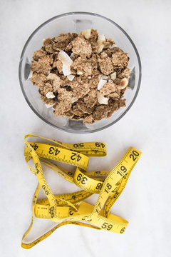 bowl of cereal with measuring tape, concept of slimming and healthy diet